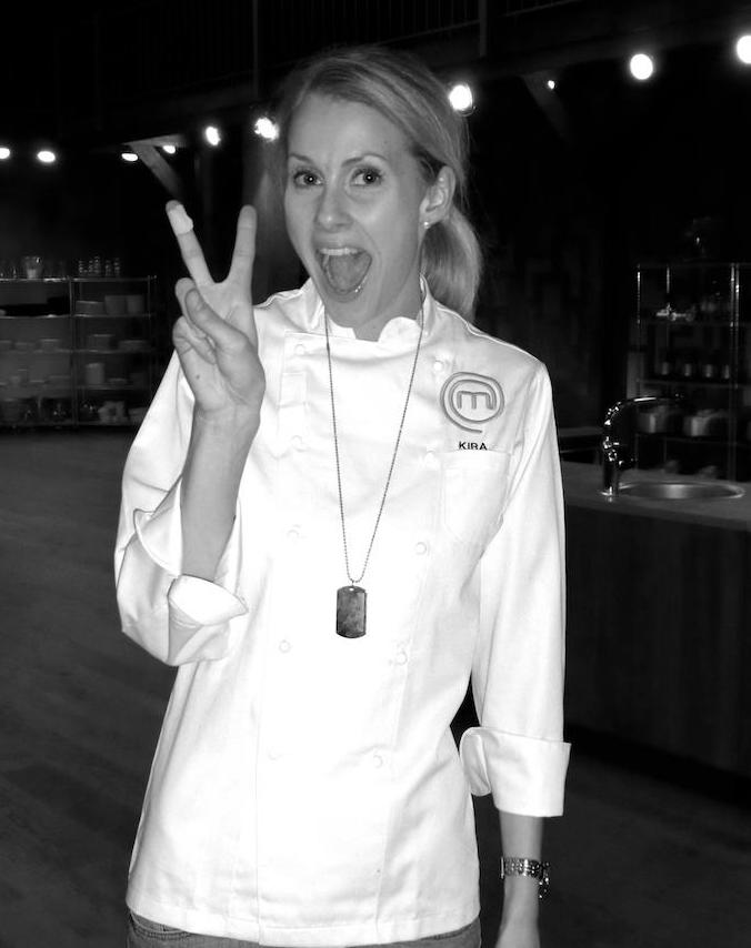 Kira showing a peace sign with a Masterchef chef's jacket on ger